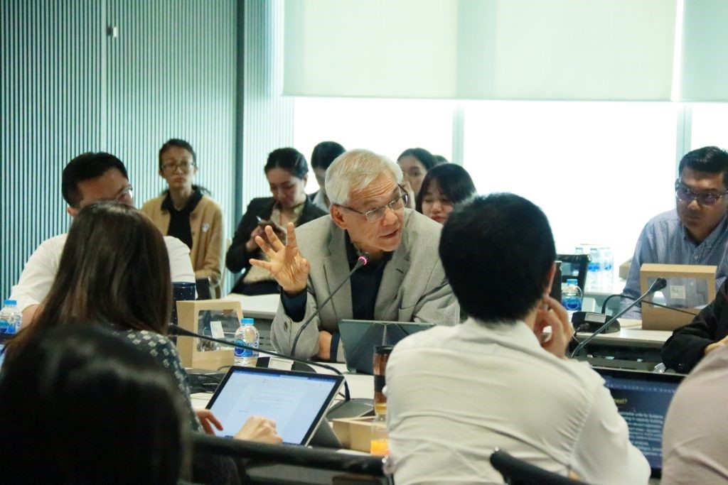 A group of people looking at a computer Description automatically generated