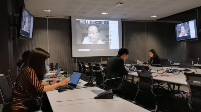 A person sitting at a desk in front of a computer  Description automatically generated