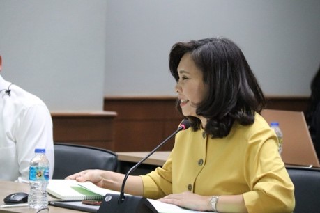 A person sitting at a desk in front of a computer Description automatically generated