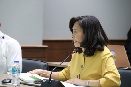 A person sitting at a desk in front of a computer  Description automatically generated