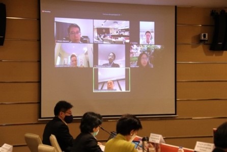 A group of people sitting in front of a computer Description automatically generated