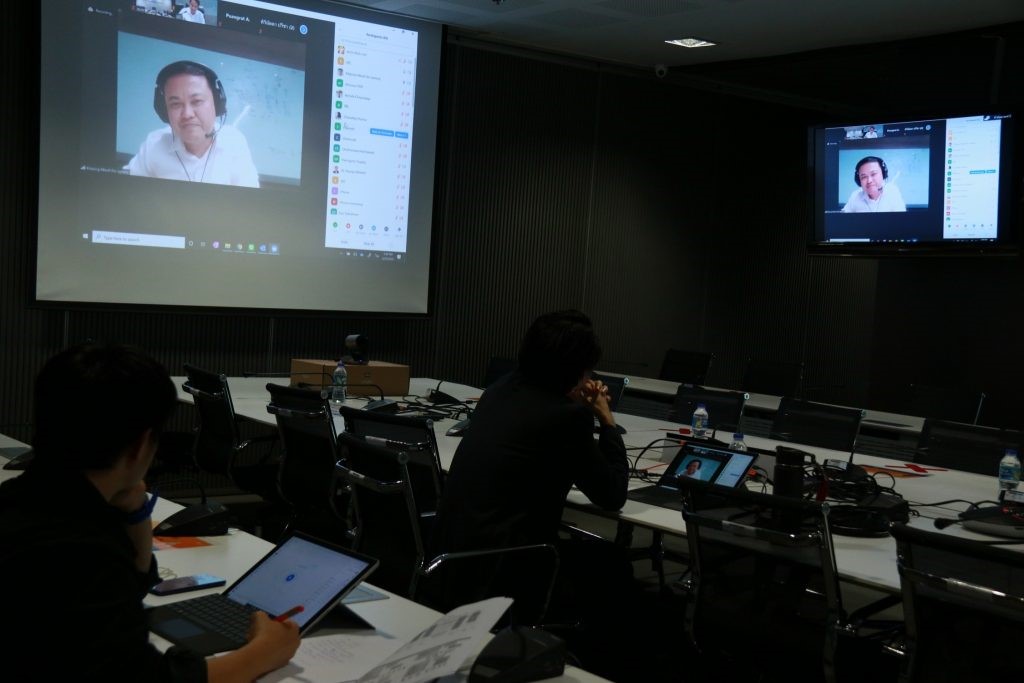 A group of people looking at a computer screen Description automatically generated
