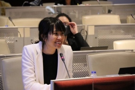 A person sitting at a table using a computer  Description automatically generated