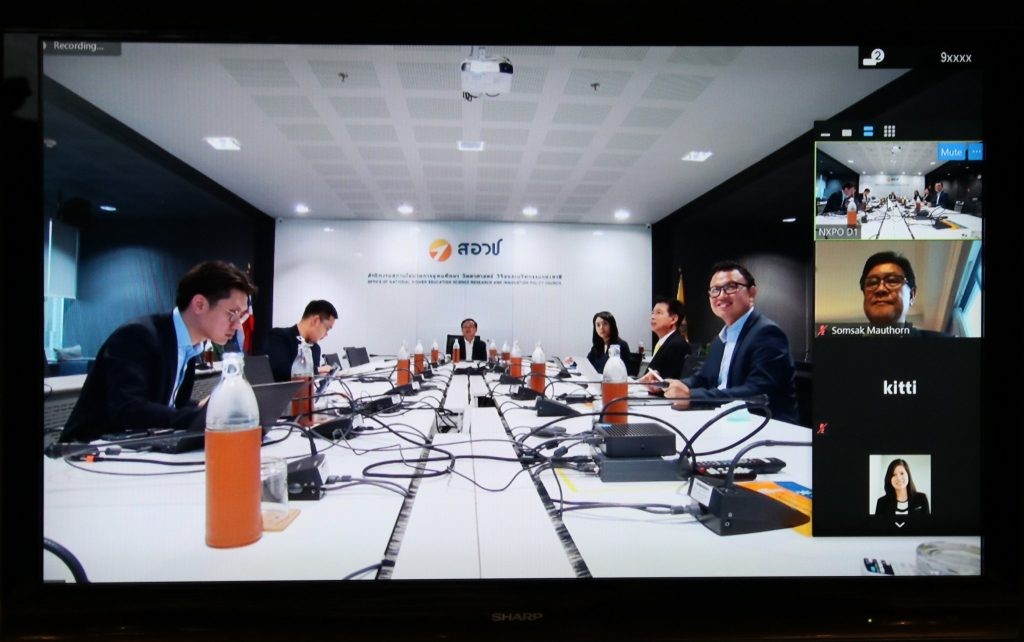 A group of people sitting at a desk  Description automatically generated
