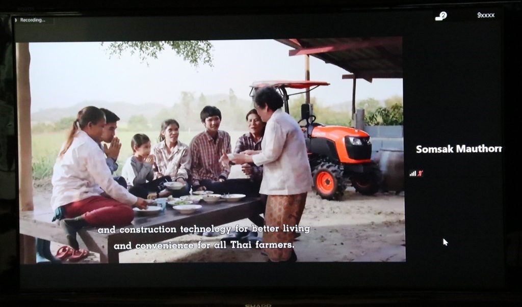 A group of people standing in front of a television  Description automatically generated