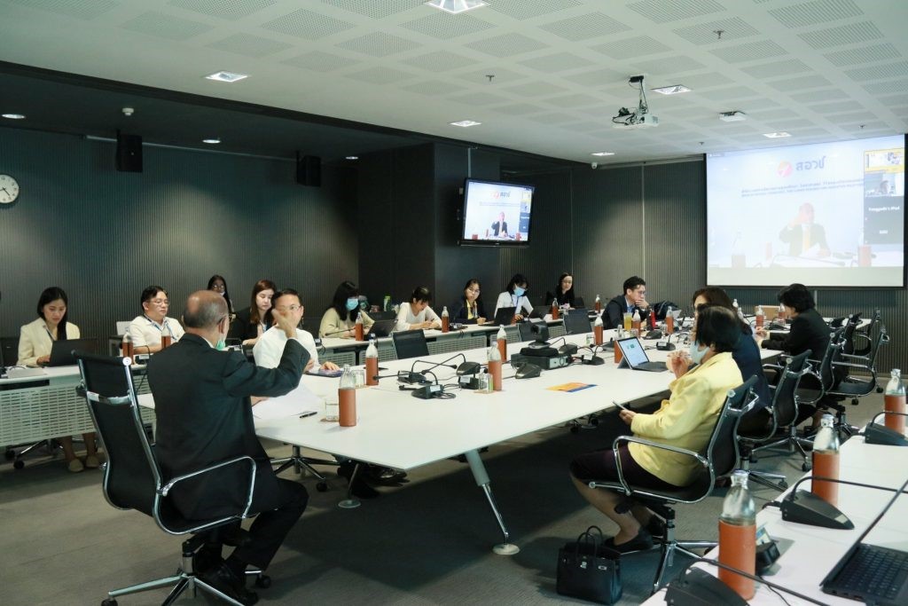 A group of people sitting at a desk in an office Description automatically generated