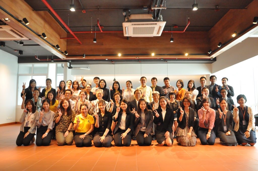 A group of people standing in front of a crowd posing for the camera  Description automatically generated