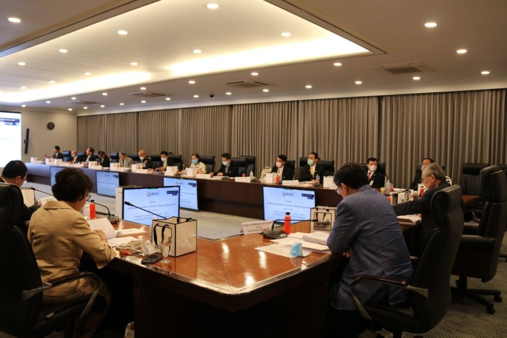 A group of people sitting at a table with computers Description automatically generated with low confidence