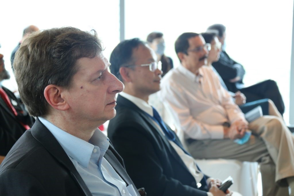 A picture containing person, person, suit, conference room Description automatically generated