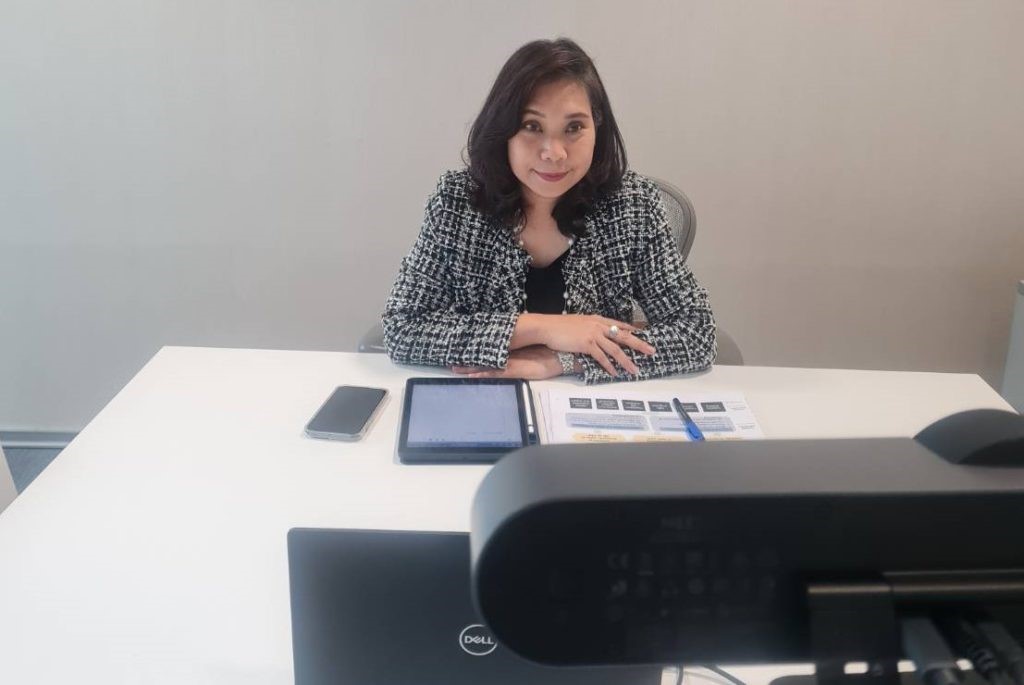 A person sitting at a desk Description automatically generated